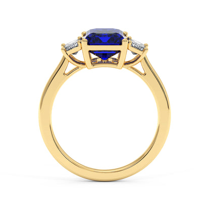 Gold 3.5 carat blue sapphire ring with large blue gemstone and two smaller white diamonds. Elegant, luxurious design.