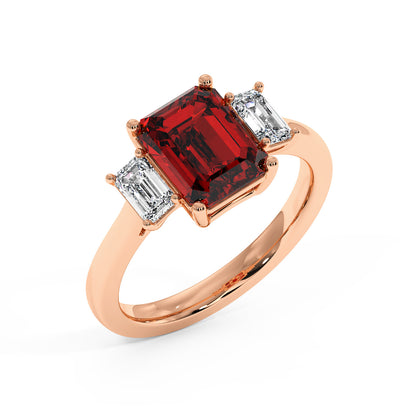 Top view of rose gold 3.5 carat ruby ring with red emerald-cut gemstone and two smaller rectangular stones.