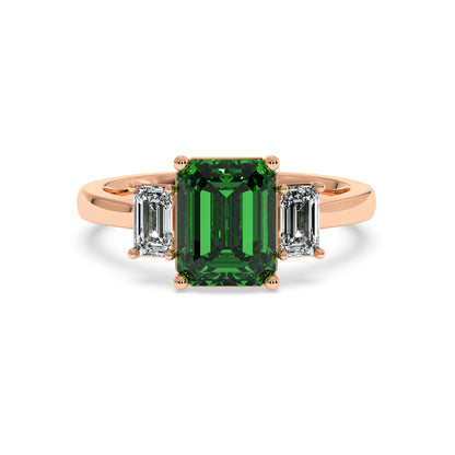Rose gold 3.5 carat emerald cut ring with green gemstone and two smaller emerald-cut diamonds. Elegant look.