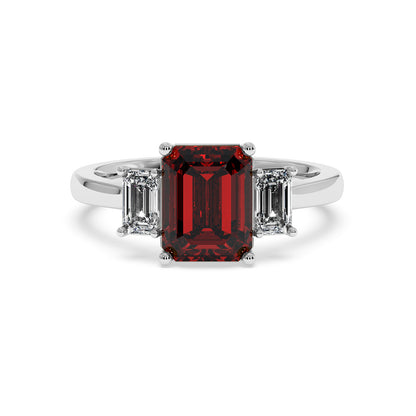14k white gold 3.5 carat emerald cut ring with deep red gemstone centered and two smaller emerald-cut diamonds.