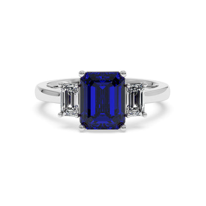 Luxurious 14k white gold 3.5 carat blue sapphire ring with emerald-cut center stone and two smaller rectangular diamonds.