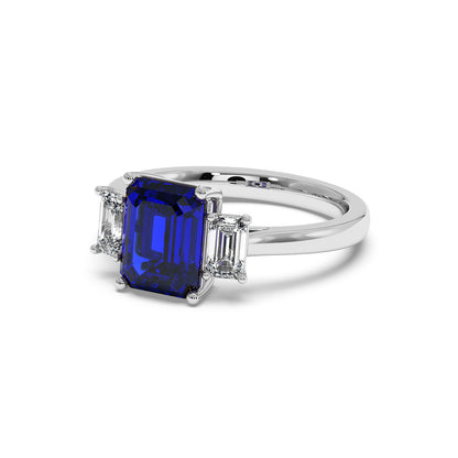 14k white gold 3.5 carat blue sapphire ring with rectangular center stone and two smaller clear diamonds.