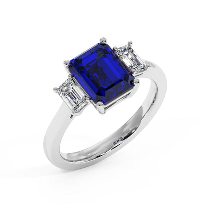 Top view of luxurious 14k white gold 3.5 carat blue sapphire ring with emerald-cut center stone and two smaller diamonds.