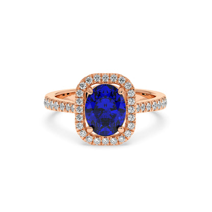 Rose gold ring with a vibrant 2.50CT blue oval sapphire surrounded by a halo of small diamonds, creating an elegant and luxurious look.
