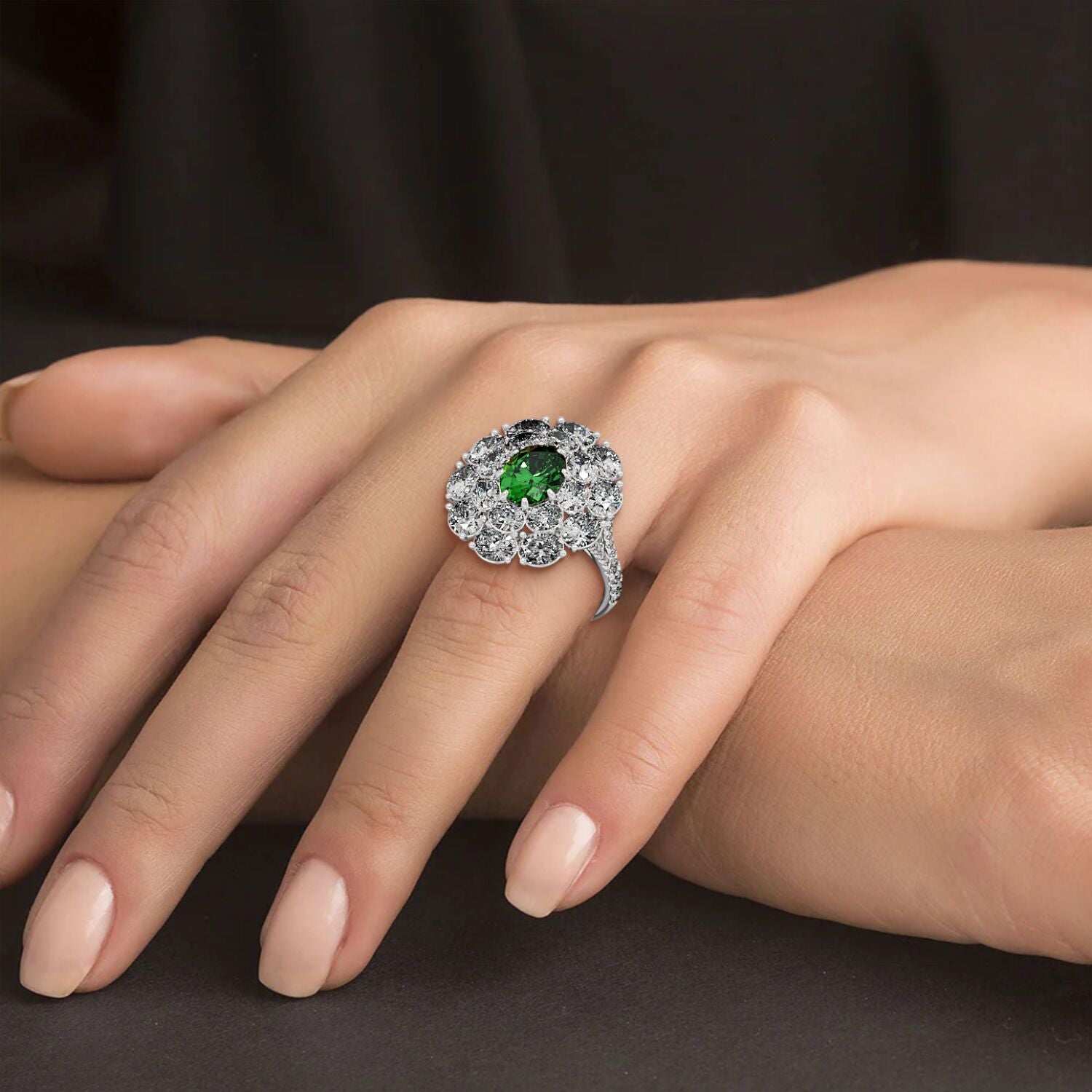 A hand displays an elegant 14k white gold ring with a 2.50CT oval green YAG surrounded by sparkling diamonds, exuding luxury.