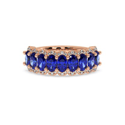 14k rose gold ring with a row of oval Blue Sapphire gemstones, bordered by sparkling white diamonds.