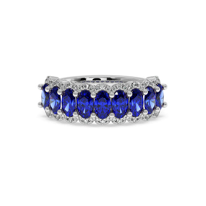 14k white gold ring adorned with a row of oval-cut Blue Sapphires, surrounded by small, sparkling diamonds.