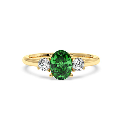 A gold ring features an oval green Y.A.G flanked by two round white diamonds, exuding elegance and sophistication against a white background.