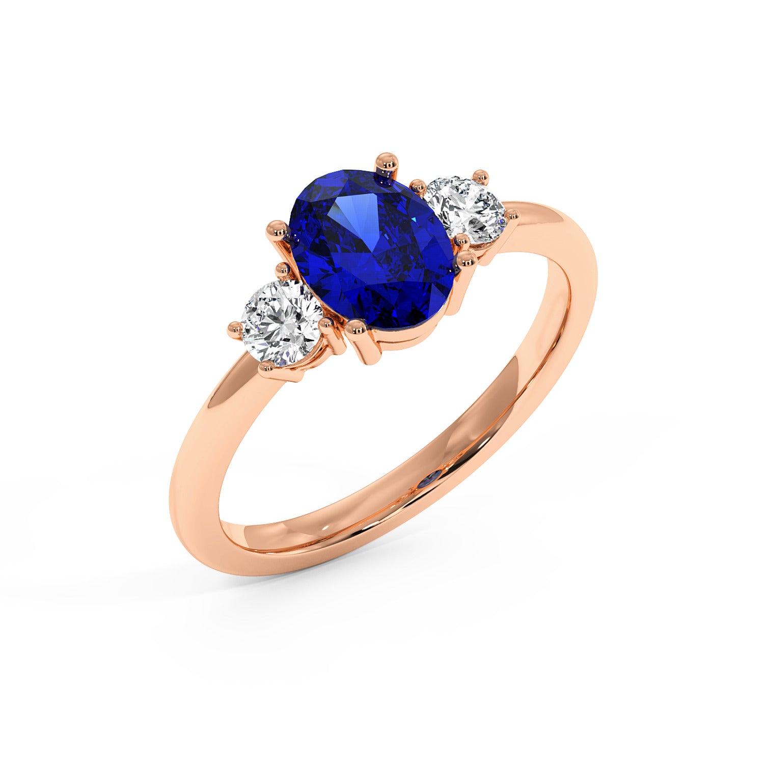 Top view of rose gold 1.75CT oval sapphire ring with blue center gemstone flanked by two round white diamonds. Elegant design.