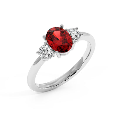 Top view of 14k white gold oval ruby ring with red center stone flanked by two round clear diamonds.