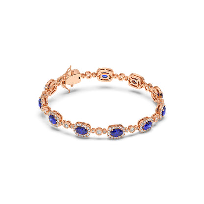 14k rose gold bracelet with oval blue sapphires encircled by small diamonds, linked delicately.