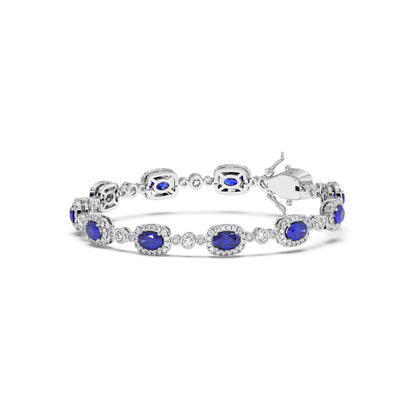 Elegant 14k white gold bracelet featuring oval-cut blue sapphire gemstones encircled by sparkling white stones.