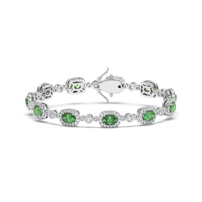 Elegant 14k white gold bracelet with sparkling oval emeralds surrounded by small clear stones.