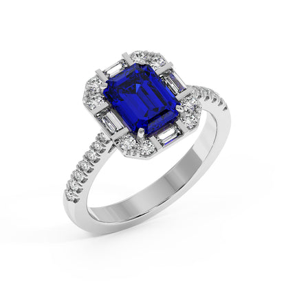 Top view of a white gold ring with a rectangular blue gemstone center, surrounded by sparkling diamonds and a diamond-adorned band. 