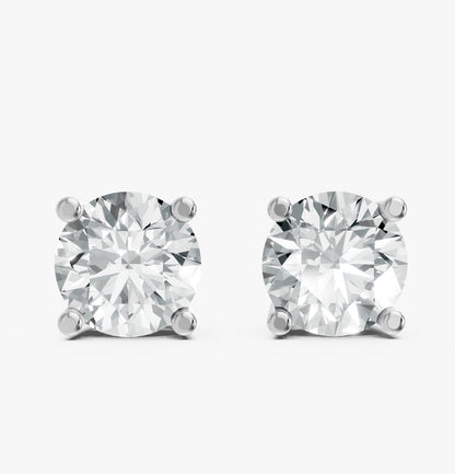 Two sparkling round diamond earrings are set in simple 925 silver prongs against a white background.