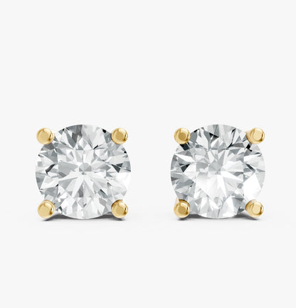 A pair of dazzling round diamond stud earrings are set in Gold plated prongs on a white background.