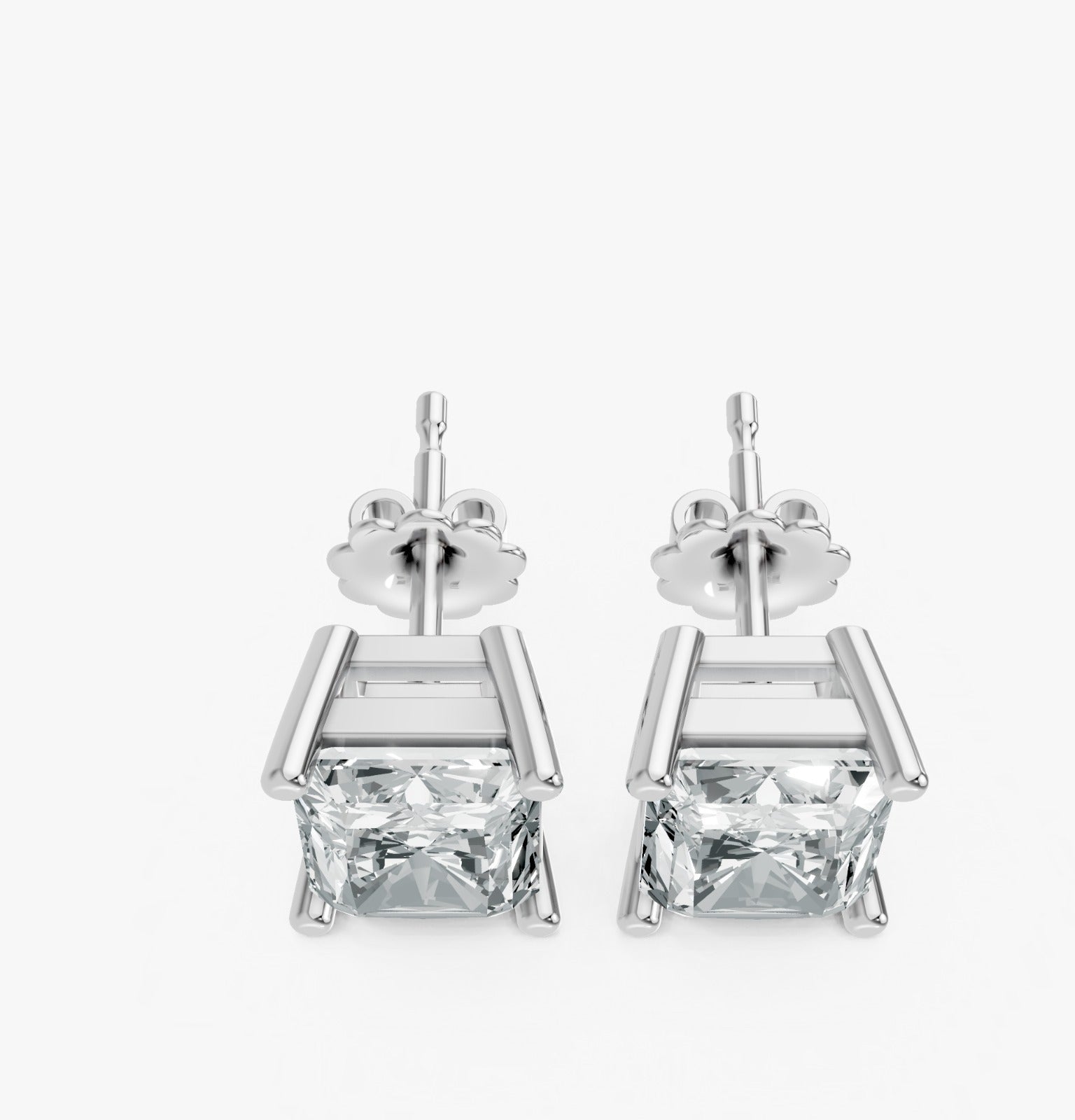 A pair of silver stud earrings feature radiant cut lab-grown gemstones in a sleek prong setting. Exuding elegance and simplicity.