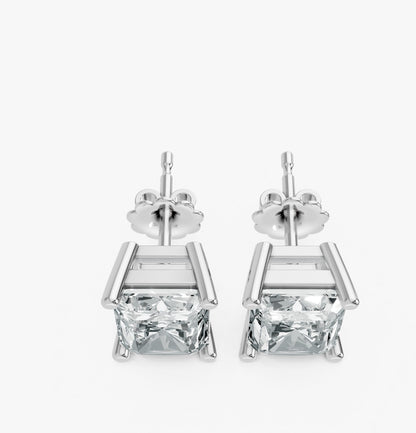 A pair of silver stud earrings feature radiant cut lab-grown gemstones in a sleek prong setting. Exuding elegance and simplicity.
