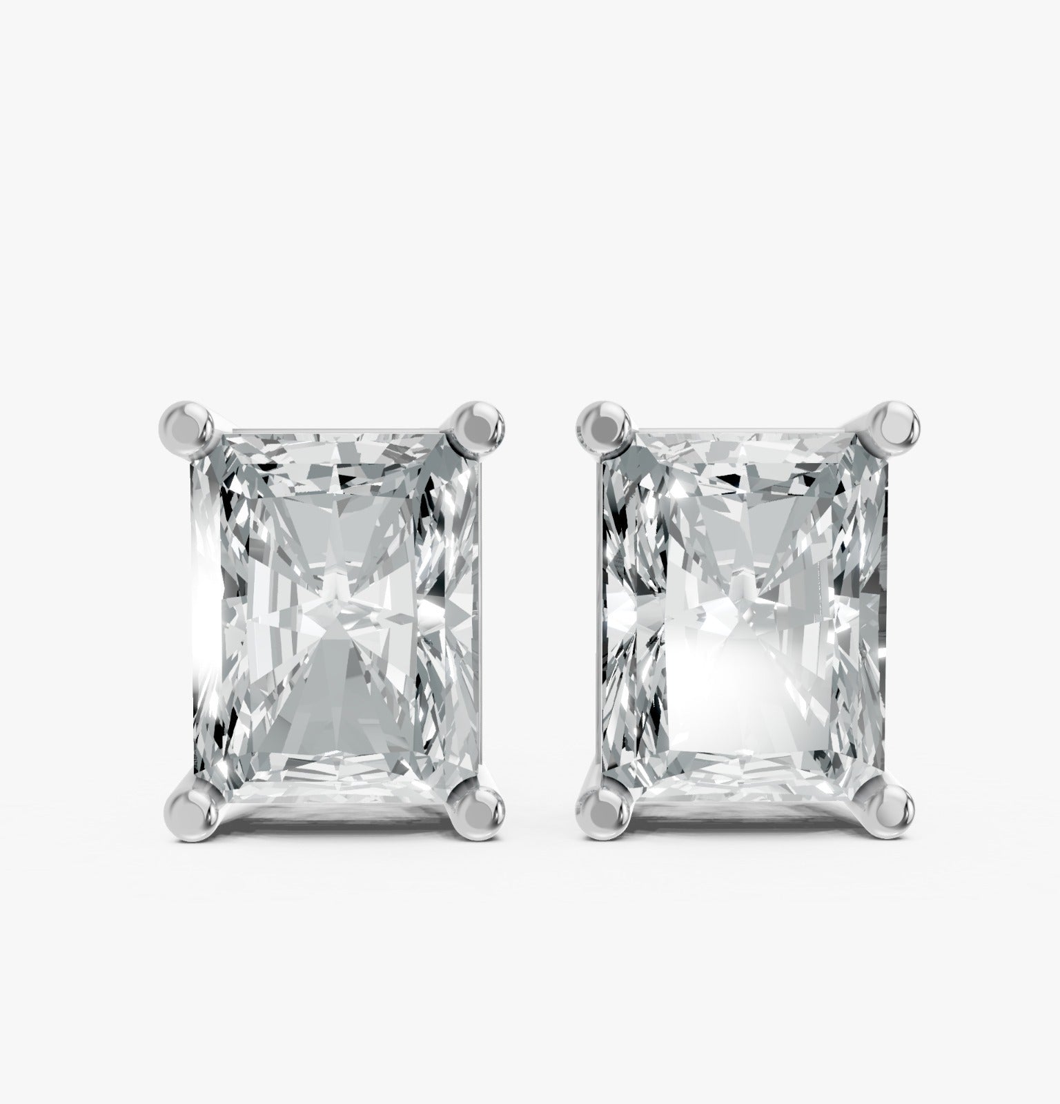 Two radiant-cut lab-grown rectangular diamond earrings in sleek silver prong settings on white. Showcases brilliance and elegance.