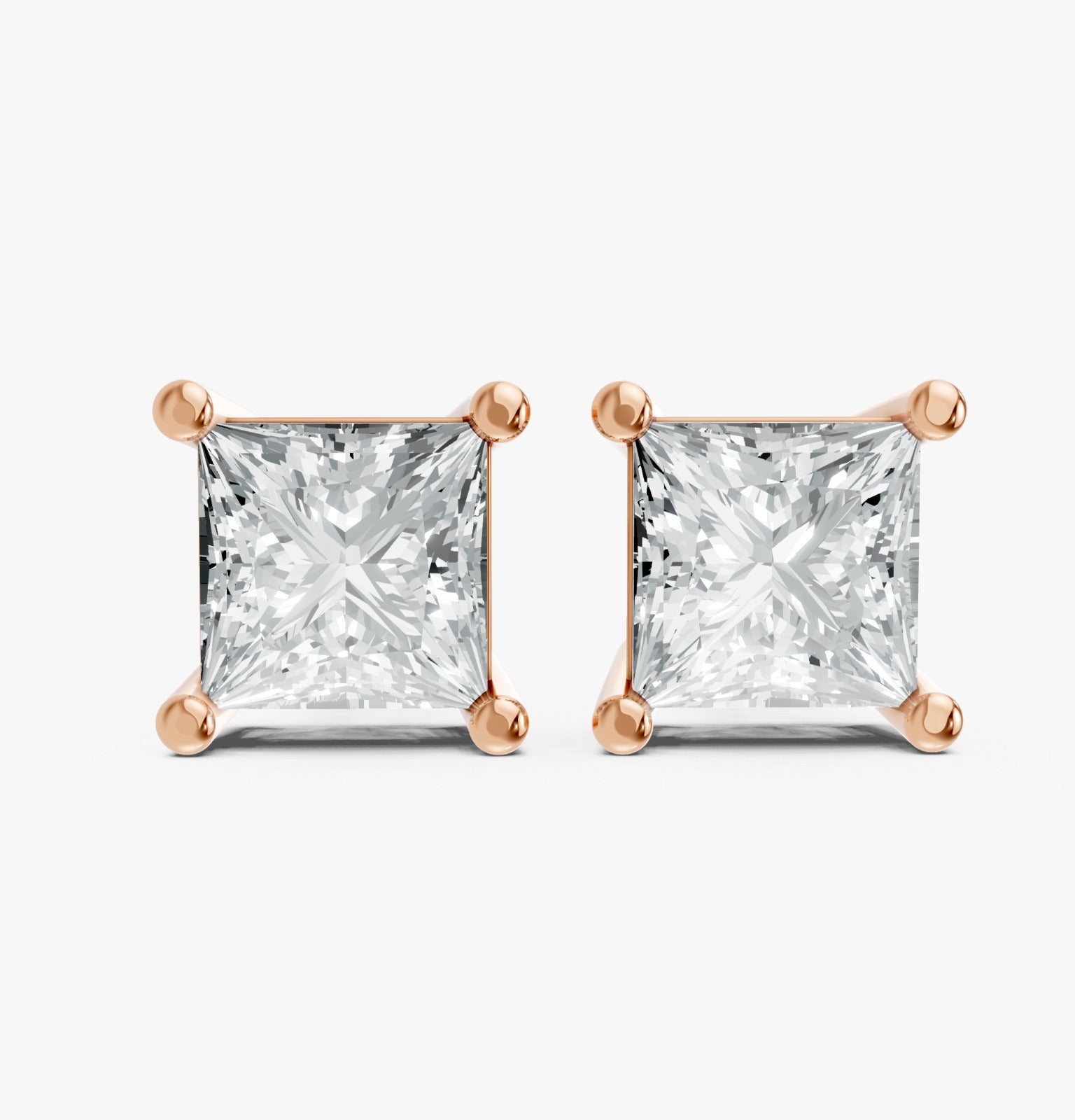 Two princess cut lab-grown diamond stud earrings set in rose gold plated prongs on a white background. Showcasing elegance, luxury, and bright sparkle.