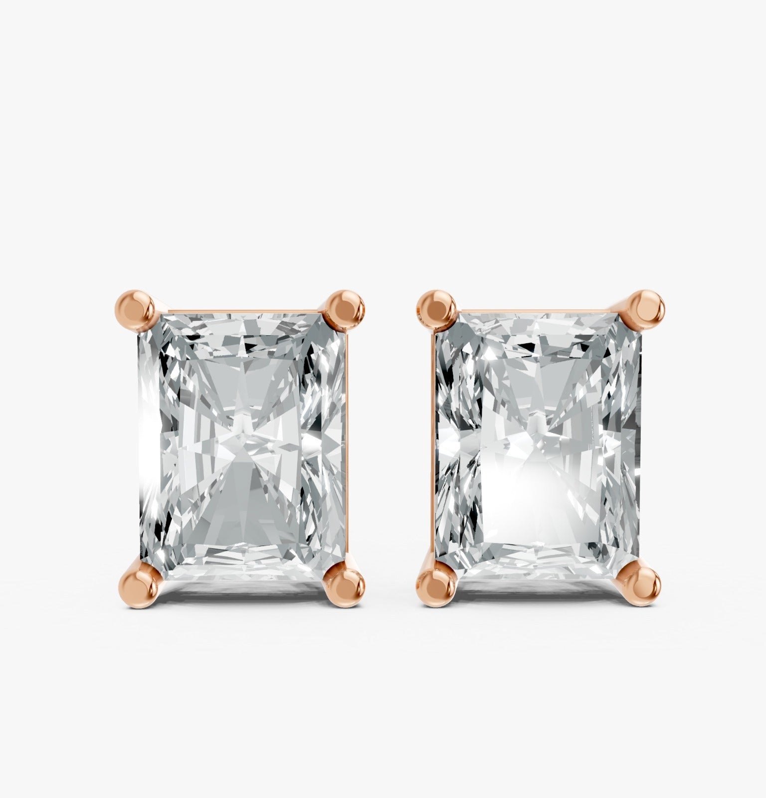 Pair of radiant-cut lab-grown diamond stud earrings set in rose gold plated prongs. Against a white background, reflecting elegance and simplicity.